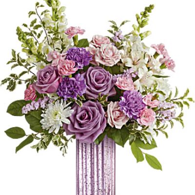 Elevate Mother's Day with Teleflora's Lavender Bliss Bouquet, featuring a stunning lavender mercury-inspired glass vase and a lush bouquet of lavender roses, pink spray roses, purple carnations, and other delightful blooms for a simply glamorous and timeless gift.